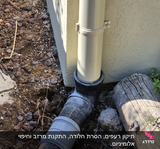 צינור ניקוז ליד קיר חיצוני עם אדמה מסביב